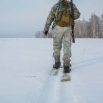 Hunter in winter walking with snow shoes or skis
