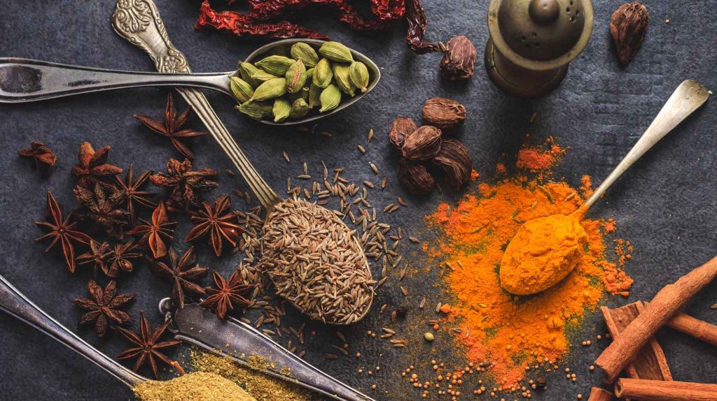 A collection of spices, including star anise, turmeric, and cumin seeds.