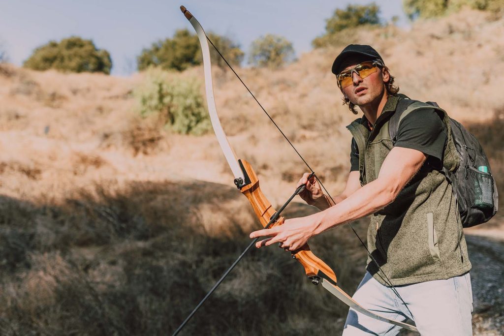 a man is bow hunting with a longbow